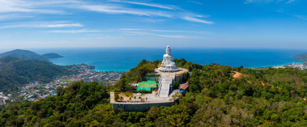 Белый мраморный Большой Будда высотой 45 метров на холме Наккерд на фоне залива Чалонг на Пхукете в золотой час